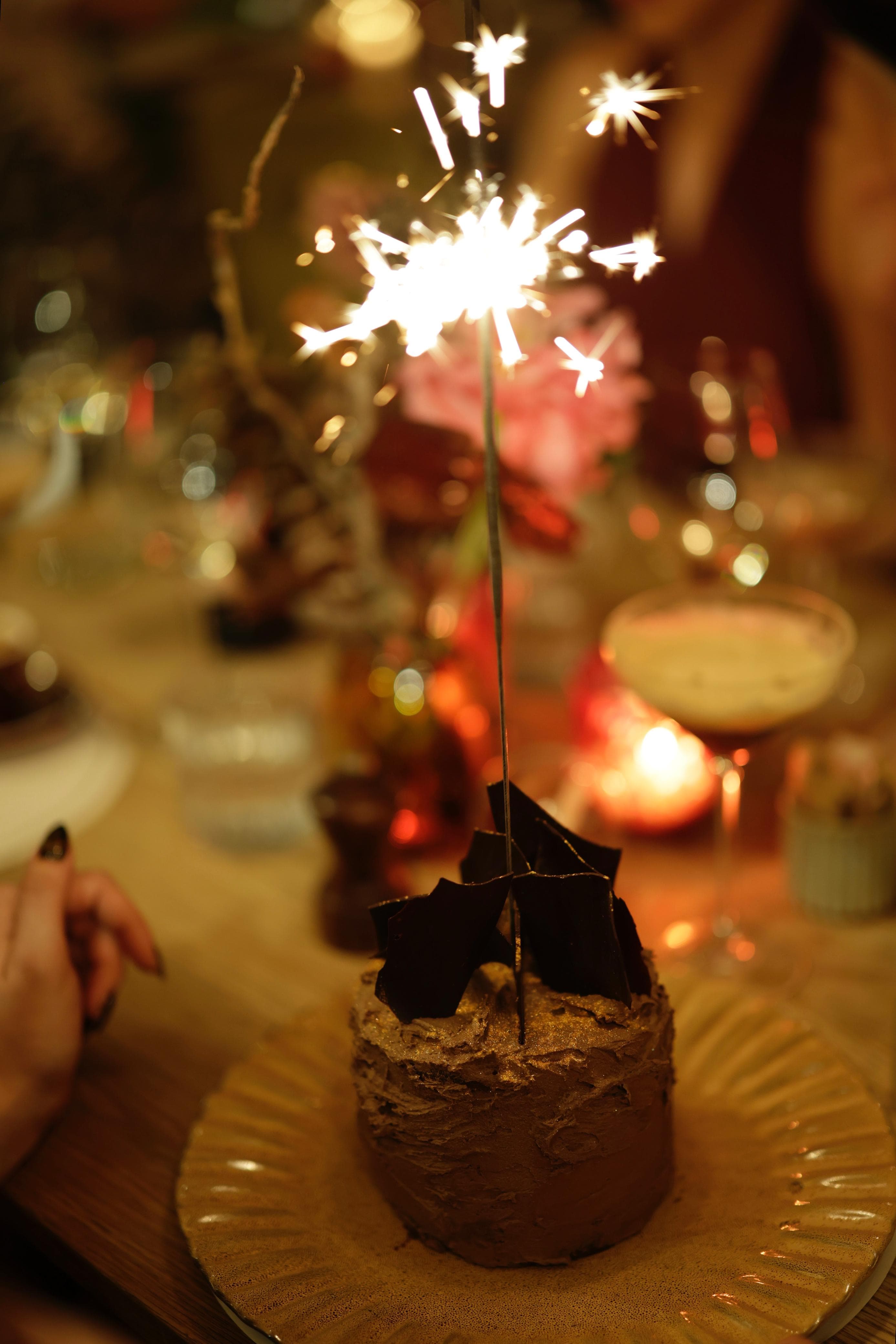 A chocolate birthday cake lit with a sparkler at Mantra Café