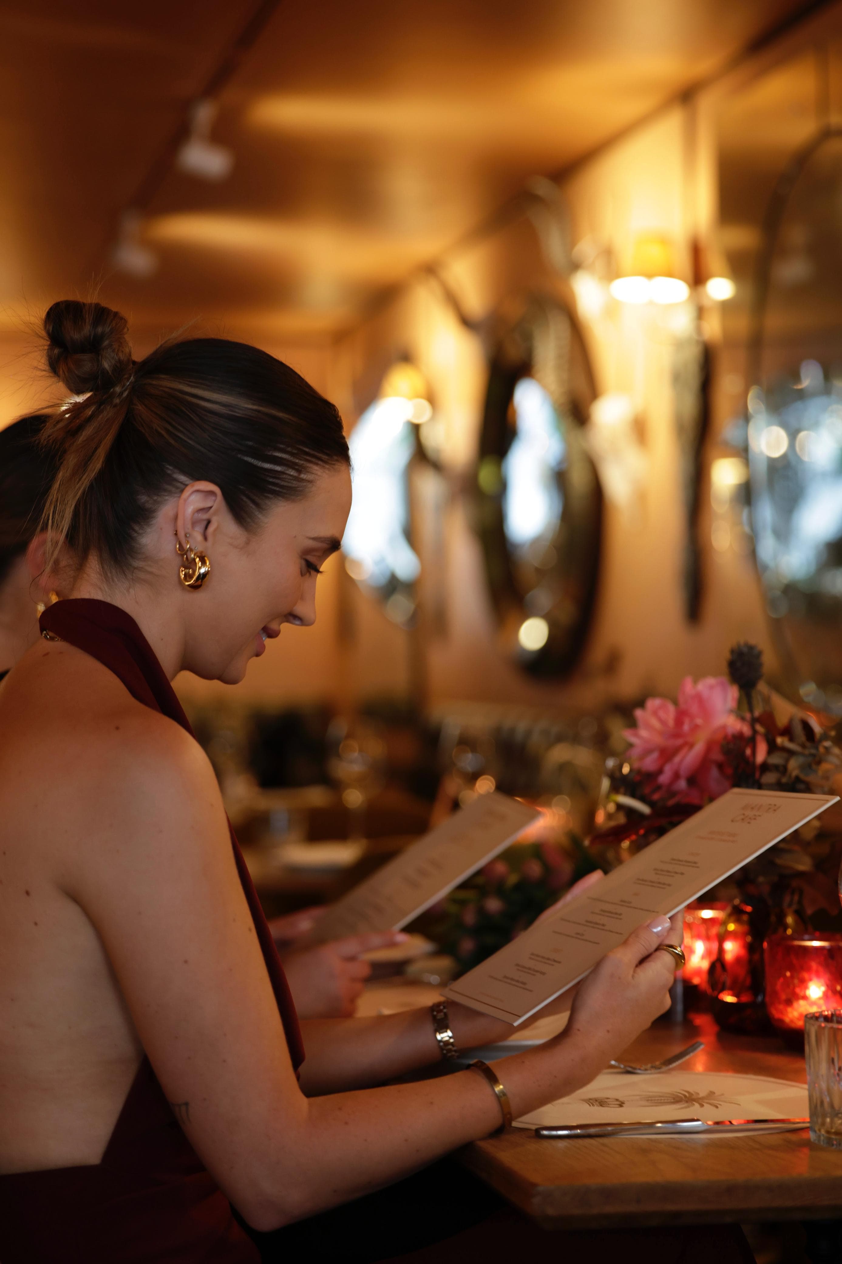 A guest reading the Mantra menu under the warm interior lighting