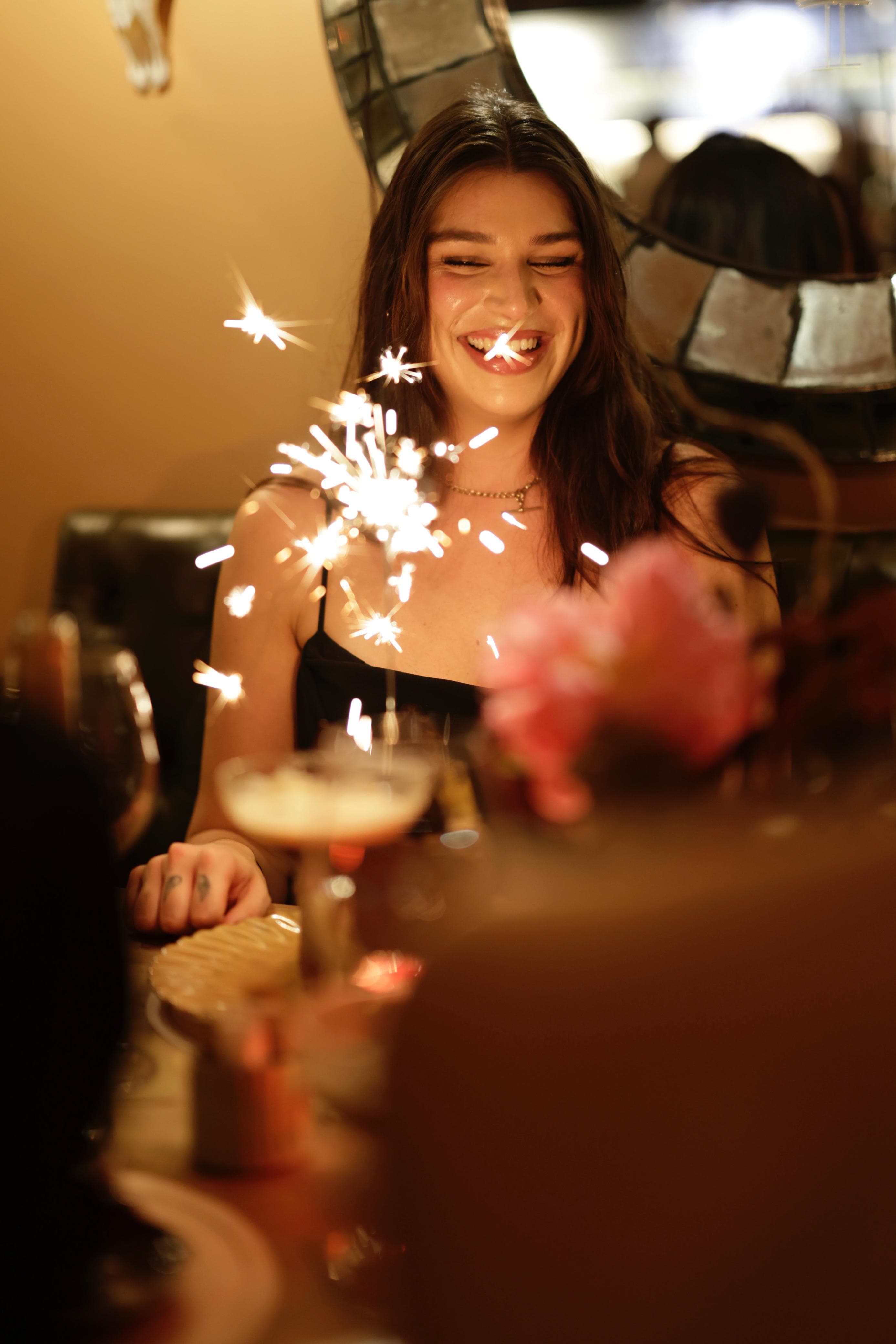 A birthday guest laughing as the sparklers fly